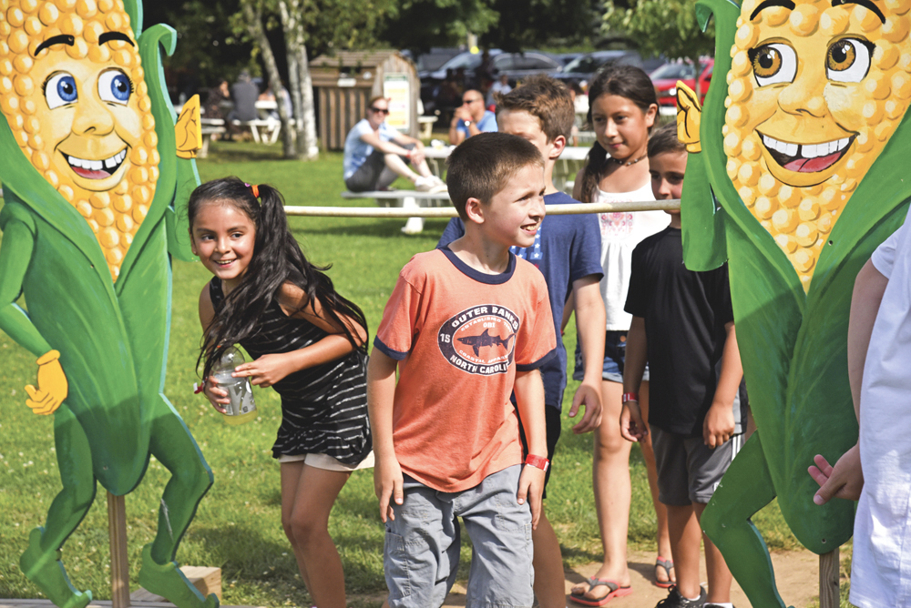 Kids having fun in the Barnyard Adventure area playing limbo