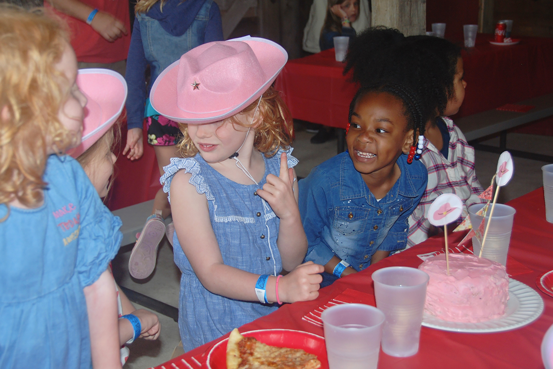 Little girls smiling and eating pizza inside Barnyard Party Barn